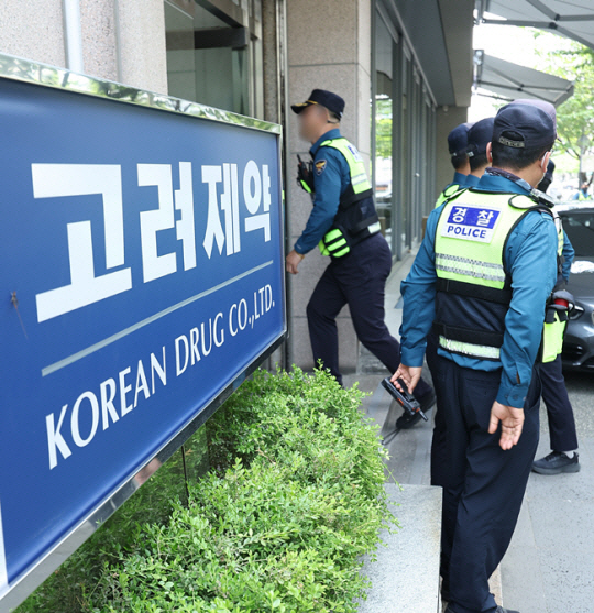 경찰 관계자들이 압수수색을 위해 서울 강남구 고려제약 본사 앞에 서 있다. 연합뉴스