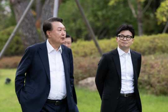 윤석열 대통령이 21일 서울 용산 대통령실 파인그라스 앞에서 한동훈 국민의힘 대표와 실내 면담에 앞서 함께 산책하며 대화를 나누고 있다. 대통령실 제공