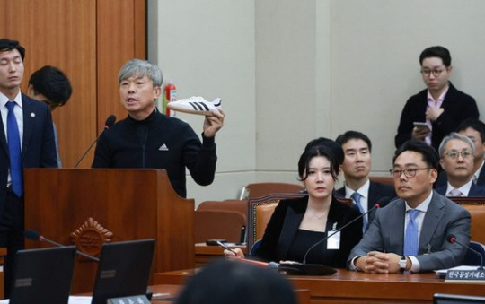 피터 곽(오른쪽) 아디다스코리아 대표가 21일 국정감사에서 통역과 함께 출석해 김정중(왼쪽) 아디다스점주협회장의 발언을 듣고 있다. 연합뉴스