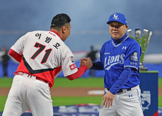 삼성의 박진만 감독(오른쪽)과 KIA의 이범호 감독이 21일 광주KIA챔피언스필드에서 열린 한국시리즈 1차전을 앞두고 인사를 나누고 있다.뉴시스