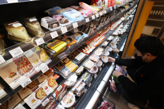 울의 한 편의점에서 고객이 진열된 도시락을 고르고 있다. 식자재 인플레이션으로 음식 가격이 치솟자 한 끼를 편의점 도시락으로 해결하려는 ‘편도족(편의점 도시락족)’이 늘어나는 추세다. 연합뉴스