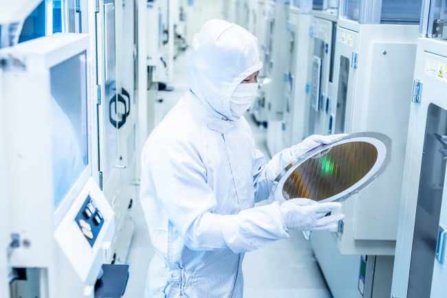 Cleanroom technician inspecting a silicon wafer