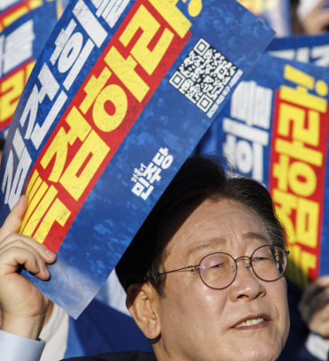 이재명 더불어민주당 대표가 2일 서울 중구 서울역 일대에서 더불어민주당 주최로 열린 김건희 윤석열 국정농단 규탄·특검 촉구 국민행동의 날에 참석해 손팻말을 들고 있다. 연합뉴스
