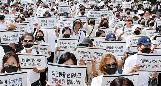 지난 3일 오후 서울 용산구 대통령실 앞에서 열린 ‘의학교육평가원 무력화 저지를 위한 전국의과대학 교수 결의대회’에서 참가자들이 피켓을 들고 구호를 외치고 있다. 뉴시스