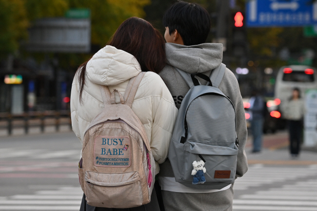 전날보다 기온이 10도 이상 떨어진 5일 오전 서울 중구 세종대로 사거리에서 한 커플이 팔짱을 낀 채 보행 신호를 기다리고 있다.   백동현 기자
