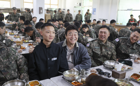 7일 육군 7포병여단 758대대에서 진행된 더본코리아의 특식 제공 행사에서 백종원(오른쪽 3번째) 더본코리아 대표와 조리병 김태윤 병장이 기념촬영하고 있다. 국방부 제공