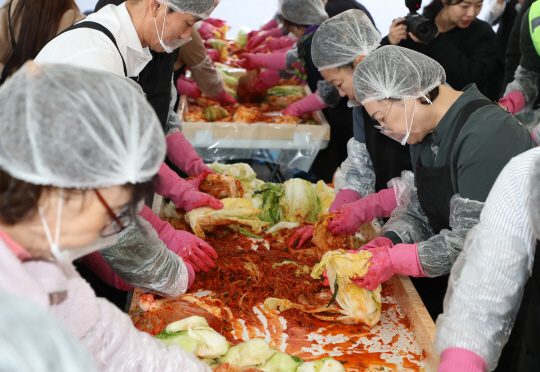 지난 11일 서울 용산구 한남동 공영주차장에서 열린 김장김치 버무림 체험 행사에서 자원봉사자들이 김장김치를 버무리고 있다. 용산구청 제공