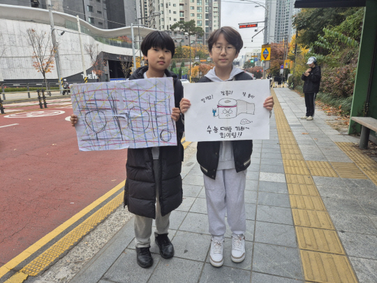 2025학년도 대학수학능력시험이 치러진 14일 수험생 형· 누나들을 응원하기 위해 서울 서초구 반포고 시험장을 찾았다는 이윤혁(12)·서유권 (12) 군이 ‘수능 대박 기원’ 플래카드를 보이고 있다. 노수빈 기자
