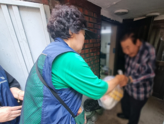 서울 영등포구의 우리동네돌봄단이 가정을 방문해 안부를 확인하며 밑반찬을 전달하고 있다. 영등포구청 제공