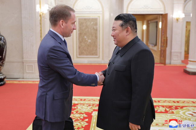 김정은(오른쪽) 북한 국무위원장이 18일 방북 중인 러시아 정부대표단 단장인 알렉산드르 코즐로프 천연자원부 장관을 만나 악수를 하고 있다.  조선중앙통신 연합뉴스