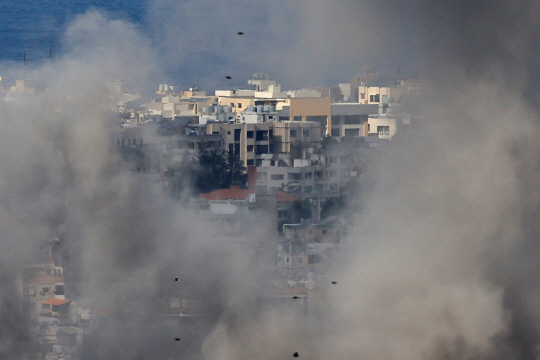 지난 25일(현지시간) 레바논의 베이루트 남부 교외 지역에서 이스라엘의 포격을 받은 건물들이 붕괴하고 있다. 로이터 연합뉴스