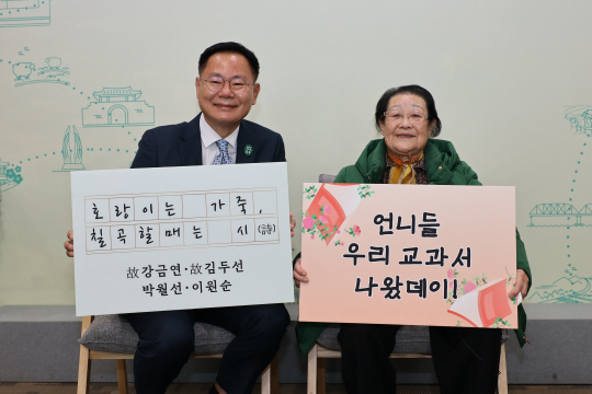 김재욱(왼쪽) 경북 칠곡군수와 천재교과서에 자신의 시가 실린 이원순 할머니가 교과서 수록을 기념하는 푯말을 들고 있다. 칠곡군청 제공