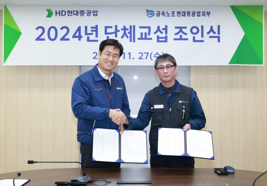 HD현대중공업 이상균(왼쪽) 사장과 백호선(오른쪽) 금속노조 현대중공업지부장이 올해 임단협 조인식을 가진뒤 악수를 나누고 있다. HD현대중공업 제공