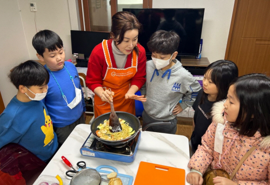 CJ올리브네트웍스 2023년도 ‘한끼의 울림’ 캠페인으로 특식을 선물받은 전남 대치지역아동센터 아동들과 교사가 직접 요리를 만들고 있다. CJ올리브네트웍스 제공