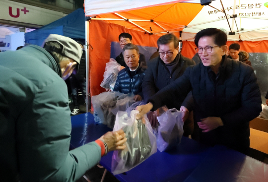 김문수 고용노동부 장관이 2일 새벽 서울 구로구 남구로역 인근 인력시장을 찾아 일용직 근로자들에게 방한용품을 전달하고 있다. 고용노동부 제공.