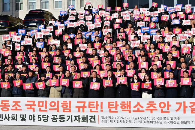 이재명(앞줄 오른쪽 일곱 번째) 더불어민주당 대표, 조국(〃여섯 번째) 조국혁신당 대표 등이 6일 오전 국회 본관 앞 계단에서 열린 ‘내란동조 국민의힘 규탄 및 탄핵소추안 가결 촉구 시민사회 및 야 5당 공동 기자회견’에서 피켓을 들고 구호를 외치고 있다. 문호남 기자