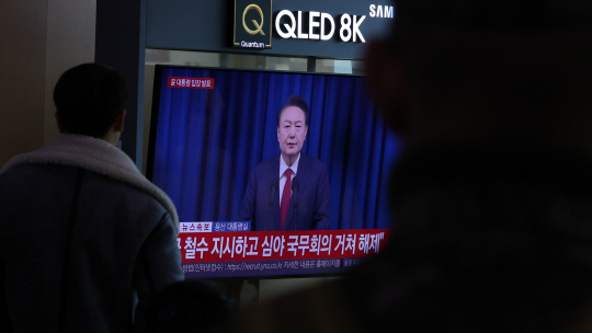 7일 오전 서울 용산구 서울역에서 시민들이 윤석열 대통령의 대국민 담화 TV 생중계를 시청하고 있다. 뉴시스