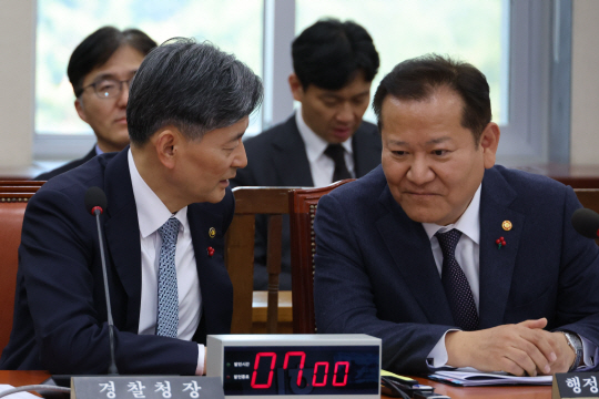 이상민 행정안전부 장관과 조지호 경찰청장이 5일 오후 비상계엄 선포와 대응과 관련한 긴급 현안질의가 진행되는 국회 행정안전위원회 전체회의에 출석해 대화하고 있다. 연합뉴스