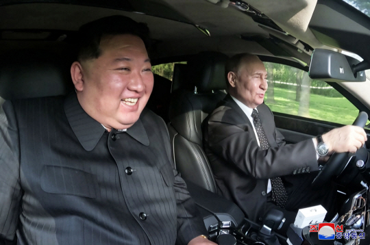 김정은(왼쪽) 북한 국무위원장이 2024년 6월 20일 금수산영빈관 정원구역에서 국빈 방문한 블라디미르 푸틴 러시아 대통령이 운전하는 차량 조수석에 앉아 담화를 나누고 있다. 조선중앙통신 캡처.