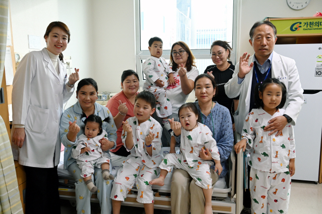 지난달 25일 인천 남동구 가천대길병원 암센터 병동에서 몽골 심장병 어린이와 보호자들이 심우섭(뒷줄 오른쪽 첫 번째) 소아청소년과 교수와 연소영(왼쪽 첫 번째) 사회복지팀장과 함께 손하트를 만들면서 환하게 웃고 있다.  곽성호 기자