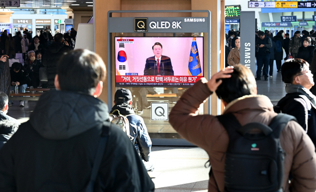 시민들이 12일 오전 서울 중구 서울역 대합실에서 윤석열 대통령이 대국민담화를 발표하는 모습을 지켜보고 있다. 윤성호 기자