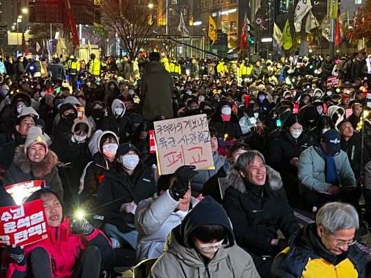 10일 서울 영등포구 여의도 국회 앞에서 열린 탄핵집회에서 한 시민이 육군사관학교 폐교를 주장하는 내용의 피켓을 들고 있다. 이시영 기자