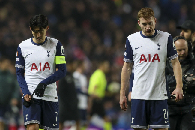 토트넘 홋스퍼의 손흥민(왼쪽)과 데얀 쿨루세브스키가 13일 오전(한국시간) 영국 스코틀랜드 글래스고의 아이브록스 스타디움에서 열린 UEFA 유로파리그 리그 페이즈 6차전에서 레인저스와 비긴 뒤 고개를 숙인 채 그라운드를 떠나고 있다.  AP 연합뉴스