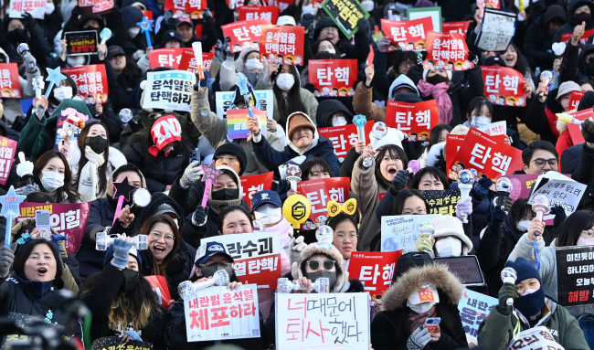 윤석열 대통령에 대한 탄핵소추안이 국회 본회의를 통과한 14일 오후 서울 여의도 국회의사당 인근에 모여든 시민들이 환호하고 있다. 윤성호 기자