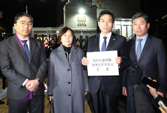 김민기 국회 사무총장(오른쪽 두 번째)과 조오섭 국회의장 비서실장(오른쪽) 등 국회 관계자들이 윤석열 대통령 대한 탄핵소추의결서 등본을 대통령실에 송달하기 위해 14일 오후 서울 용산 대통령실 민원실로 들어가기 앞서 발언하고 있다. 연합뉴스(대통령실통신사진기자단)