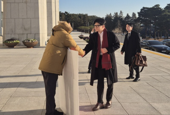 한동훈 국민의힘 대표가 14일 오전 서울 여의도 국회에서 출근하며 윤석열 대통령 탄핵 표결 찬성 1인 시위 중인 김상욱 의원과 악수하고 있다. 김상욱 의원실 제공