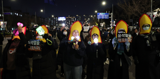 7일 오후 서울 여의도 국회 앞에서 열린 ‘내란죄 윤석열 퇴진! 국민주권 실현! 사회대개혁! 범국민촛불대행진’참가자들이 응원봉을 흔들며 탄핵안 표결 처리를 촉구하고 있다. 연합뉴스