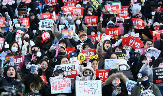 윤석열 대통령에 대한 탄핵소추안이 국회 본회의를 통과한 14일 오후 서울 여의도 국회의사당 인근에 모여든 시민들이 환호하고 있다. 윤성호 기자