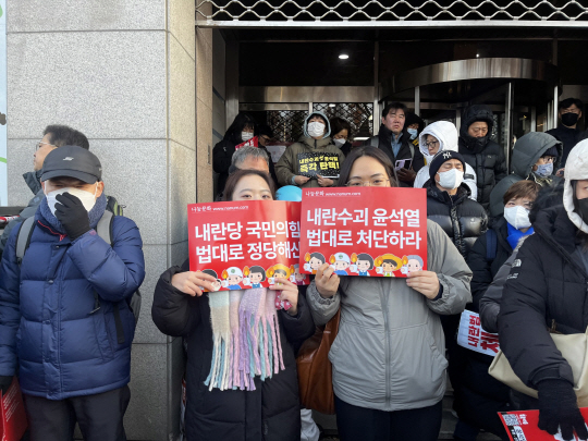 14일 서울 영등포구 여의도 국회 앞에서 열린 ‘탄핵 집회’에서 대학교 동기 사이인 민설희(23) 씨외 임예은(23)씨가 피켓을 들고 있다. 이시영 기자.