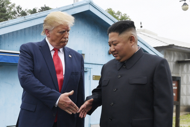 도널드 트럼프(왼쪽) 미국 대통령 당선인이 집권 1기 시절인 2019년 6월 30일 판문점에서 김정은 북한 국무위원장과 만나 악수를 하기 위해 손을 내밀고 있다.  AP 뉴시스