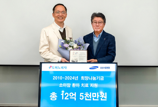오광현(오른쪽) 한국도미노피자 회장과 박승우 삼성서울병원장이 17일 서울 강남구 삼성서울병원에서 소아암 환아 치료 지원을 위한 1억 원 기부금 전달식을 진행한 뒤 기념사진을 찍고 있다. 한국도미노피자 제공