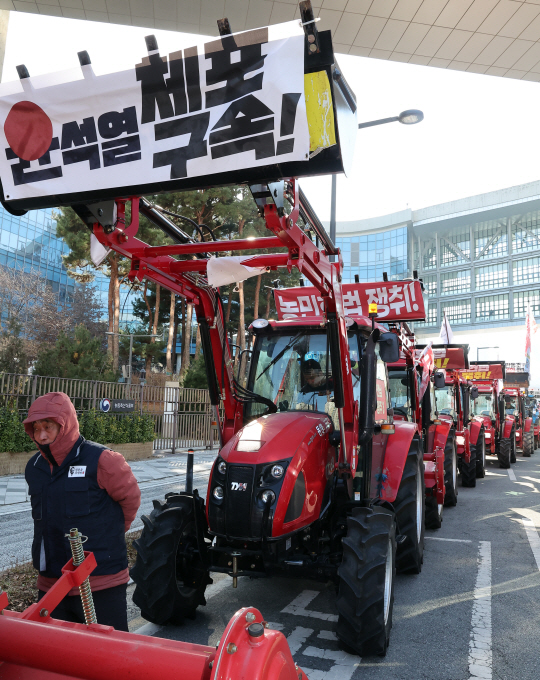 트랙터와 트럭 수십 대를 몰고 상경 행진 중인 전국농민회총연맹 전봉준 투쟁단 소속 농민들이 지난 19일 정부세종청사 농림축산식품부 앞에서 "윤석열 체포ㆍ구속 및 송미령 장관 탄핵ㆍ처벌"을 외치며 시위를 벌이고 있다.   연합뉴스