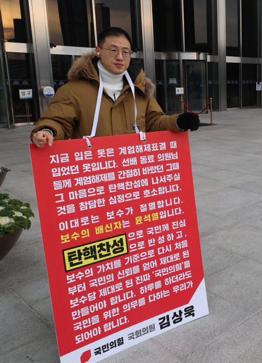 김상욱 국민의힘 의원이 13일 오후 서울 여의도 국회 본청 입구에서 국민의힘 의원들에게 윤석열 대통령 탄핵 찬성 투표를 호소하는 1인 시위를 하고 있다. 뉴시스