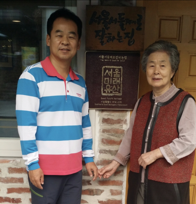 지난 2016년 ‘팥죽 할머니’ 김은숙(오른쪽) 씨와 아들 가광위 씨가 ‘서울서 둘째로 잘하는 집’ 앞에서 다정하게 포즈를 취했다. 1976년 문을 연 가게는 서울미래유산으로 지정돼 있다.   가광위 씨 제공