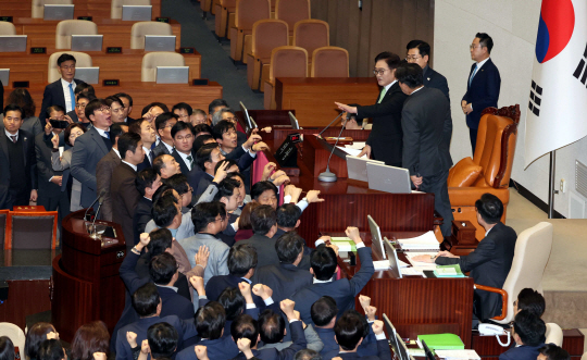 우원식 국회의장이 27일 오후 국회에서 열린 제420회국회(임시회) 제2차 본회의에서 국무총리(한덕수) 탄핵소추안을  상정하자 국민의힘 의원들이 단상을 점거하고 ‘원천무효’  ‘국회의장 사퇴’ 구호를 외치고 있다. 뉴시스