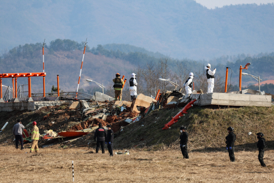 29일 오후 전남 무안공항에서 소방 당국이 착륙 도중 충돌로 추정되는 사고가 난 여객기 주변 화재 현장 수색구조 활동을 벌이고 있다. 뉴시스