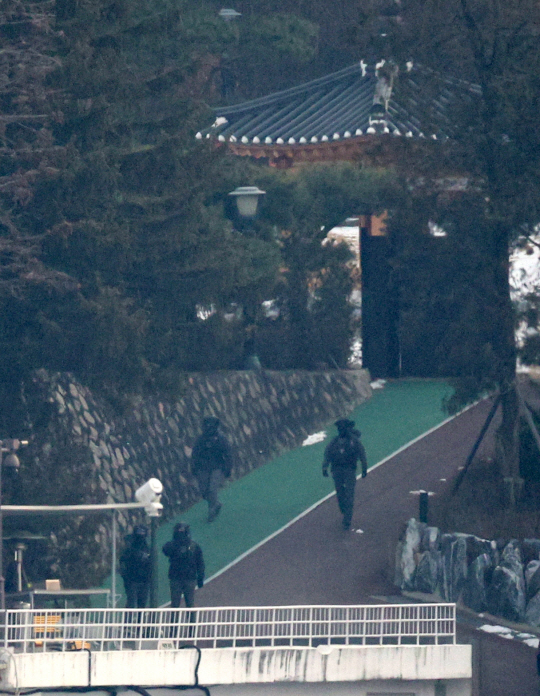 윤석열 대통령에 대한 고위공직자범죄수사처와 경찰의 2차 체포영장 집행 시도가 임박한 13일 서울 용산구 한남동 대통령 관저에서 전술복과 헬멧을 착용한 경호처 공격대응팀(CAT) 추정 요원들이 중무장 순찰을 하고 있다. 뉴시스 제공