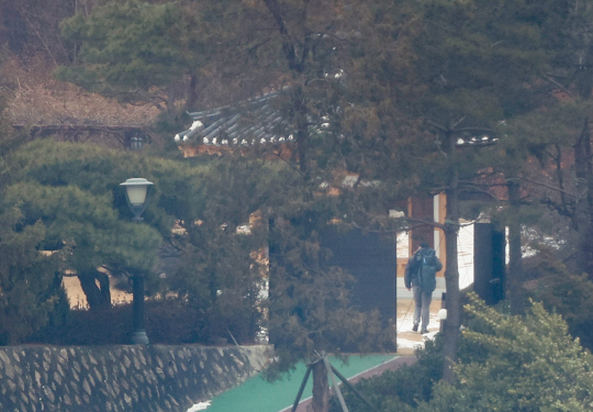 고위공직자범죄수사처(공수처)가 윤석열 대통령에 대한 체포영장을 재발부받은 지 일주일을 맞은 13일 서울 용산구 한남동 대통령 관저에서 경호처 대테러과 소속으로 추정되는 직원이 순찰하고 있다. 연합뉴스