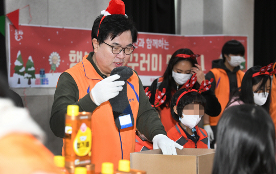 박일하(왼쪽) 동작구청장이 지난해 행복나눔 꾸러미 봉사활동에 참여해 자원봉사자들과 함께 상자에 물품을 담고 있다. 동작구청 제공