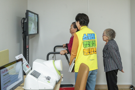 서울 양천구 신원 스마트경로당에서 고령자들이 동행매니저의 도움을 받으며 스마트워킹 기기를 이용하고 있다. 양천구청 제공