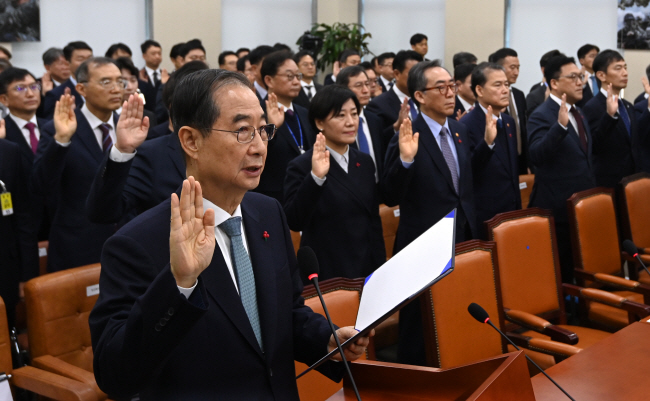 국회의 탄핵소추안 의결로 직무정지 중인 한덕수(앞줄 왼쪽) 국무총리를 비롯해 국무위원 등이 15일 오전 국회에서 열린 ‘윤석열 정부의 비상계엄 선포를 통한 내란 혐의 진상규명 국정조사 특별위원회’ 기관보고에 출석, 증인 선서를 하고 있다.  곽성호 기자