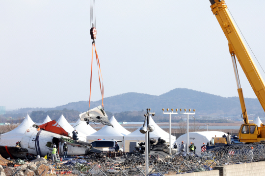 15일 오전 제주항공 참사 현장에서 소방대원 등 조사 당국 관계자들이 기체 잔해를 수습하고 있다.연합뉴스