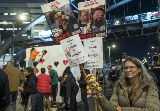 팔레스타인 무장정파 하마스와의 휴전과 인질 석방을 촉구하는 한 이스라엘 시민이 양 측의 휴전 발표 하루 전인 18일 오후 가자지구에 붙잡힌 성인 남성 인질들의 사진을 들고 1인 시위를 벌이고 있다. UPI 연합뉴스