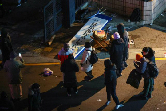 윤석열 대통령의 구속영장이 발부된 19일 새벽 서울 마포구 서울서부지법 후문에서 윤 대통령 지지자들이 부순 현판이 놓여있다. 연합뉴스