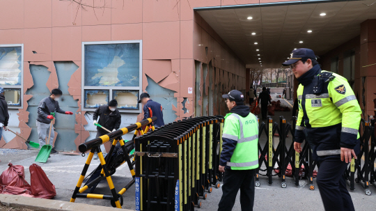 윤석열 대통령이 내란 우두머리 혐의로 구속되자 일부 윤 대통령 지지자들이 서울서부지방법원 내부로 난입해 불법폭력사태를 일으킨 19일 오후 서부지법에서 청사 관계자들이 파손된 시설물과 물품 등을 치운 뒤 복구작업을 하고 있다. 연합뉴스