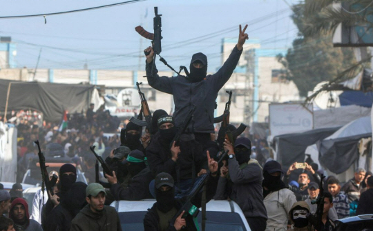 이스라엘과 팔레스타인 무장정파 하마스간의 휴전이 발효된 19일 가자지구 거리로 나와 무장한 채 행진하고 있는 하마스 대원들. X 캡처